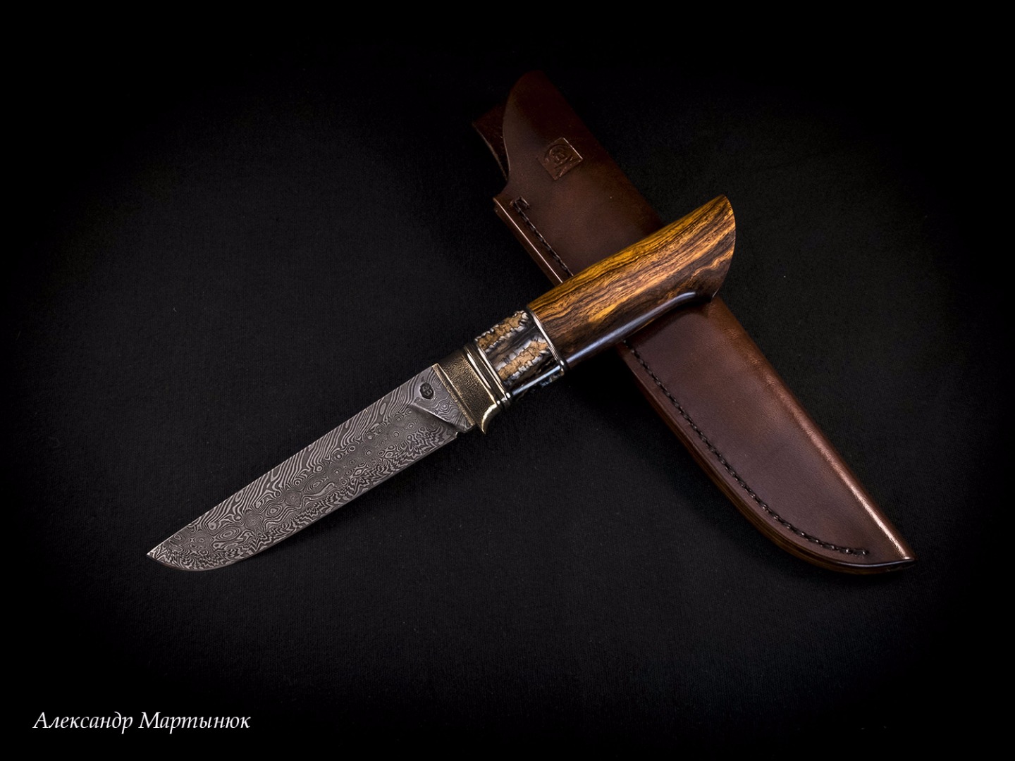 The "Iron Tooth" knife by Alexander Martynyuk (Emfitemzis) blade is a mosaic damascus, in the RK ShKh15 + U10 the handle is bronze, cupronickel, stab. Mammoth tooth, Ironwood.